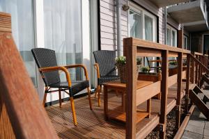 eine Veranda mit Stühlen und einem Tisch auf einem Haus in der Unterkunft Hotelletje de Veerman in Oost-Vlieland