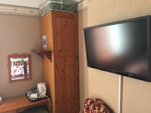 duży telewizor z płaskim ekranem wiszący na ścianie w obiekcie The Ivy House Ferry Link w mieście Stranraer