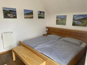 a bed in a room with pictures on the wall at Gemutliche 93m2Fewo mit 2 Schlafzimmern und seitlichem Seeblick vom Balkon in Scheid