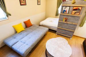 a living room with a couch and a bed at 新大阪旅庵 民泊縁家 in Osaka