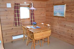 a dining room with a wooden table and chairs at Egenes Camping in Flekkefjord