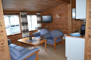 a living room with blue chairs and a table at Egenes Camping in Flekkefjord