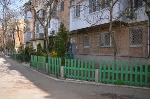 a green fence in front of a building at Apartment on Ingenernaya 17 in Mykolaiv
