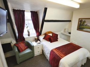 a small bedroom with a bed and a chair at South Shore Guest House in South Shields +33 photos