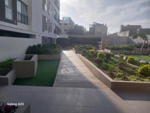 a walkway in front of a building with plants at Moderno departamento con vista panorámica cerca a los centros comerciales in Lima