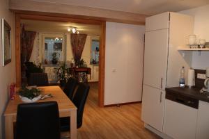a kitchen and dining room with a table and a refrigerator at Ferienwohnung Fam. Höhn in Kappel-Grafenhausen