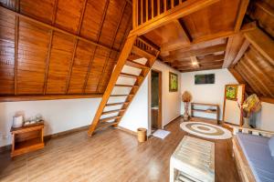 a living room with wooden ceilings and a ladder at Asasta Kintamani Villa in Kubupenlokan