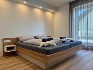 a bed in a room with a large window at Apartment, Zimmer, Ferienwohnung in Traitsching