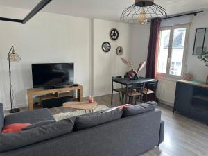 a living room with a couch and a television at L Elegant Cozy Plein Centre in Saint-Avertin