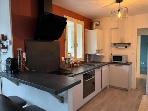 a kitchen with a counter with a tv on the wall at L Elegant Cozy Plein Centre in Saint-Avertin