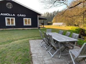 a picnic table and chairs in front of a barn at Hallamölla Gård in Brösarp