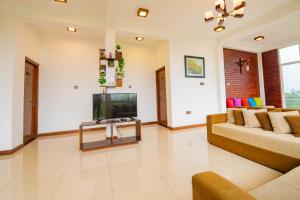 a living room with a couch and a television at Thimaya Holiday Resort in Hatton