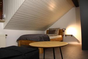 a attic room with a bed and a table at Ferienwohnung Kloep in Serrig