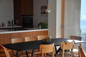 una cocina con mesa negra y sillas en Panoramic Ecodesign Apartment Obersaxen - Val Lumnezia I Vella - Vignogn I near Laax Flims I 5 Swiss stars rating en Vella