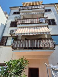 an apartment building with a balcony with a awning at Apartments Antolović in Vrsar