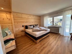 a bedroom with a bed and a wooden wall at Ferienhaus Muskatellerhof in Silz