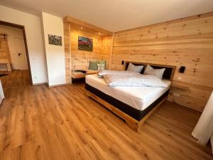 a bedroom with a bed in a wooden wall at Ferienhaus Muskatellerhof in Silz