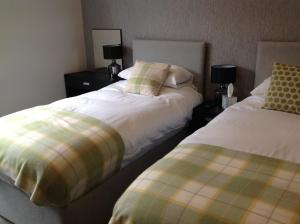 a bedroom with two beds and two nightstands at Rooms @ Number Six in Oakham