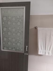- Baño con puerta de ducha y toalla en Forrthuna Mio Villa, en Negombo