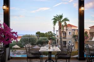 a patio with a table and chairs and a view of a pool at Lindos Imperial Resort & Spa in Kiotari