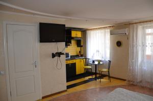 a living room with a kitchen with a tv on the wall at Apartment on Ingenernaya 17 in Mykolaiv