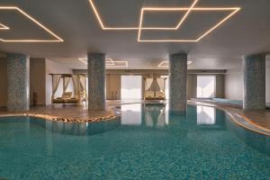 a swimming pool in a hotel with chairs and lights at Lindos Imperial Resort & Spa in Kiotari