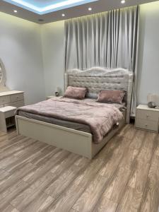 a bedroom with a large bed and wooden floors at شقة خمس غرف مطلة على طريق السودة in Abha