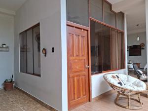a room with a wooden door and a chair at Garden House in Tarapoto