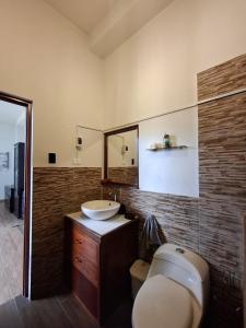 a bathroom with a sink and a toilet and a mirror at Garden House in Tarapoto