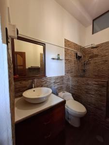a bathroom with a sink and a toilet and a mirror at Garden House in Tarapoto +61 photos