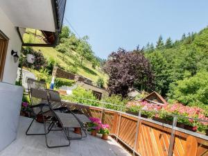 a patio with two chairs and flowers on a balcony at Gästehaus Resi in Bad Peterstal-Griesbach