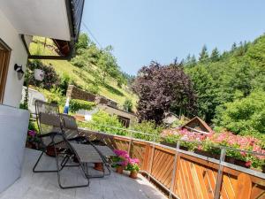 eine Terrasse mit 2 Stühlen und Blumen auf einem Balkon in der Unterkunft Gästehaus Resi in Bad Peterstal-Griesbach