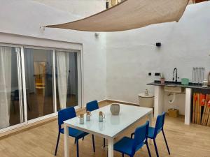 ein Esszimmer mit einem weißen Tisch und blauen Stühlen in der Unterkunft Family Home Valencia in Aldaia + 36 Fotos