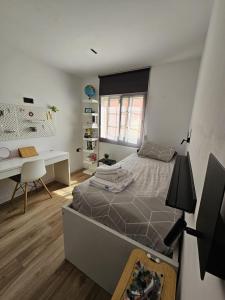 ein Schlafzimmer mit einem Bett und einem Schreibtisch in der Unterkunft Family Home Valencia in Aldaia