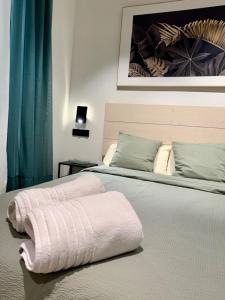 ein Schlafzimmer mit einem Bett und einem rosa Handtuch darauf in der Unterkunft Family Home Valencia in Aldaia