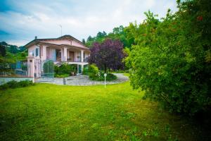 dom w ogrodzie z zielonym trawnikiem w obiekcie Bed and Breakfast Welcome w mieście Sarzana
