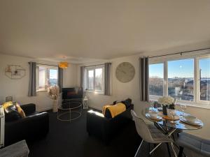 a living room with a clock on the wall at Apollo Apartment in Coventry