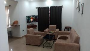 a living room with two chairs and a tv at Blue ocean apartment baga Kyle in Calangute