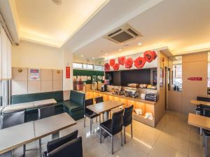 un restaurante con mesas y sillas y una cocina en Da Shih Hotel, en Hualien City