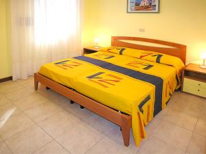 ビビオーネにあるCasa Vacanze Azaleaのベッドルーム1室(黄色い毛布付きのベッド1台付)