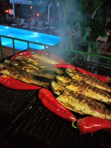 a group of meat and peppers on a grill at BEGONYA HOTEL KEMER-All İnclisuve in Antalya