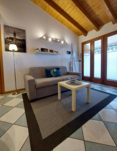 a living room with a couch and a table at Apart Dina Lazise - Garten, Klima, Pool, Parkplatz, WIFI in Lazise