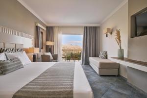 a hotel room with a bed and a balcony at Lindos Imperial Resort & Spa in Kiotari