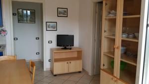 a room with a tv on a cabinet with a television at Case Sole e Luna in Porto Azzurro