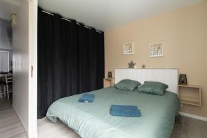 a bedroom with a large bed with blue towels on it at Le Reflet des Pyrénées in Bagnères-de-Bigorre +5 photos