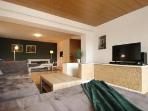 a living room with a couch and a flat screen tv at Geräumige Wohnung in Altenau mit Terrasse in Lissendorf