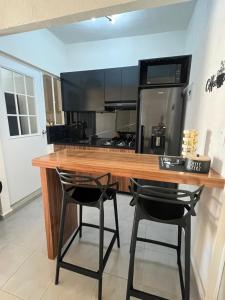 a kitchen with a wooden counter and two black chairs at Cristal diamante in Los Algodones