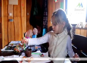 una niña sentada en una mesa comiendo comida en Hotel Zieleniec, en Zieleniec