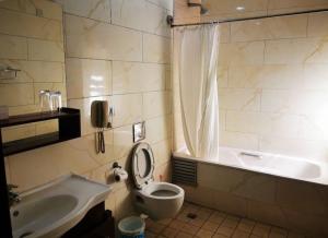 a bathroom with a sink and a toilet and a tub at OFAS Apartment in Abuja