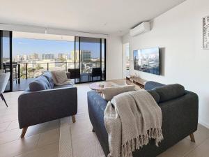 a living room with two couches and a large window at Luxury Maroochydore Apartment in Maroochydore